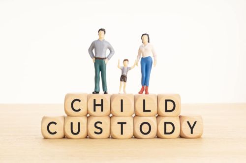 Child custody concept. Wooden blocks with text and woman, man and child figurine